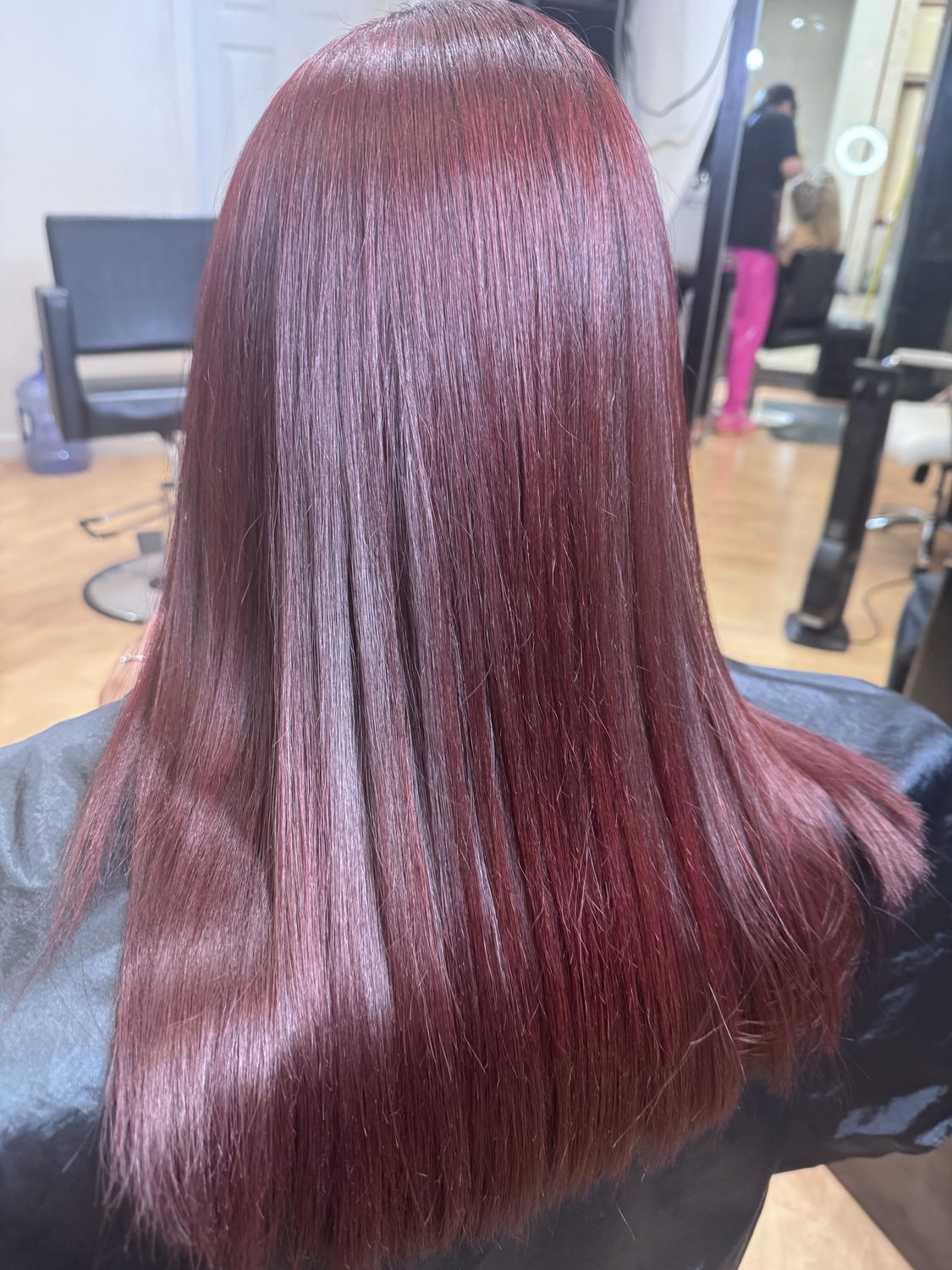 Deep burgundy gloss on long straight hair